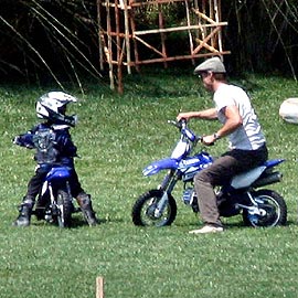 Brad brinca com uma moto no jardim