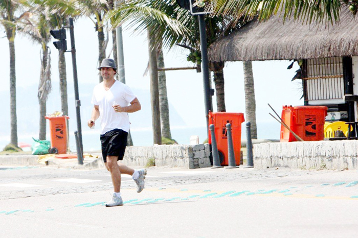 Murilo Rosa chegou correndo à praia, com chapéu e camiseta branca