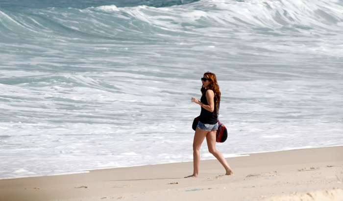 Ao chegar à praia, Miley Cyrus caminha até o mar