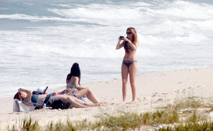 Ela fotografa as amigas na praia