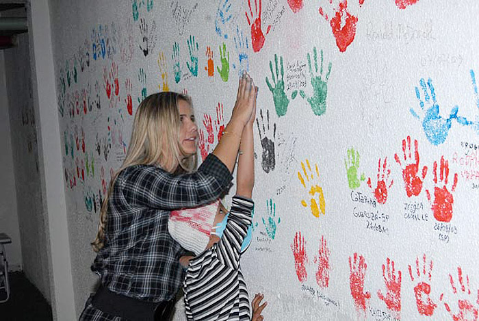 Apresentadora também ajudou uma paciente a marca as mãos na parede. 