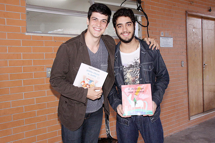Mateus Solano e Miguel Rômulo posam para foto com os livros que leram para as crianças