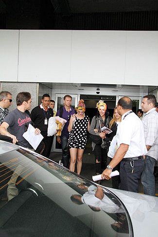 Katy Perry, de máscara, deixou o saguão do aeroporto cercada por seguranças