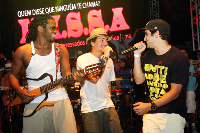 Caio Castro (de camiseta preta) canta ao lado da banda Trio Ternura