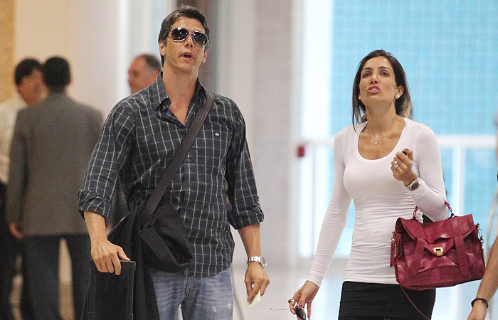 Marcio Garcia circula por aeroporto carioca com a esposa