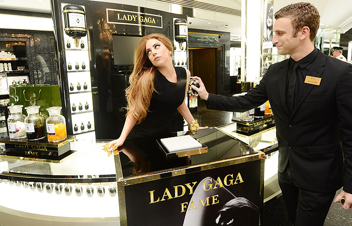 Lady Gaga usa adereços dourados nas unhas, no lançamento de seu perfume em Londres