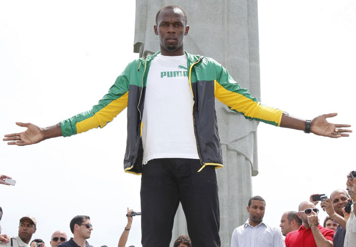 Usain Bolt faz seu característico gesto aos pés do Redentor