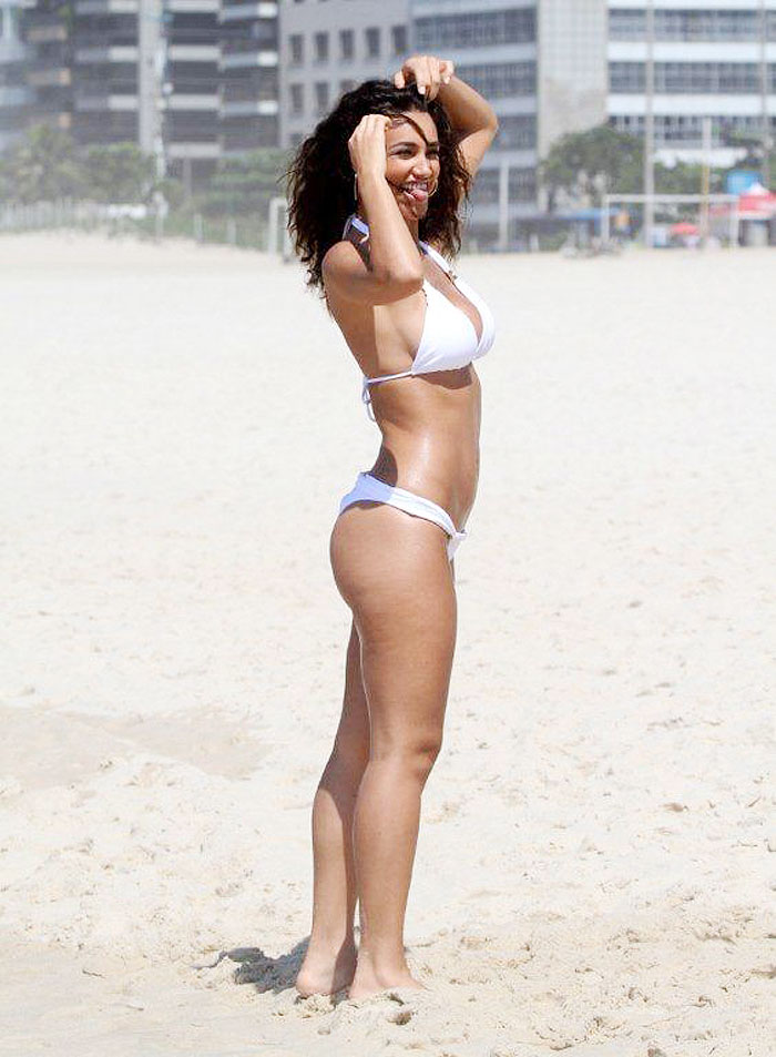 De biquíni branco, Débora Nascimento grava comercial em praia carioca