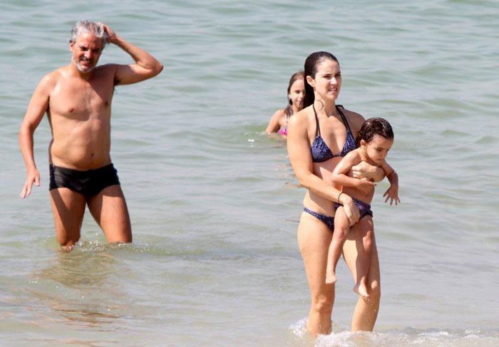Patrícia Werneck e André Barros brincam com o filho na praia