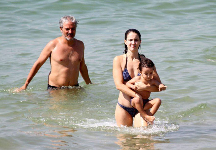 Patrícia Werneck e André Barros brincam com o filho na praia