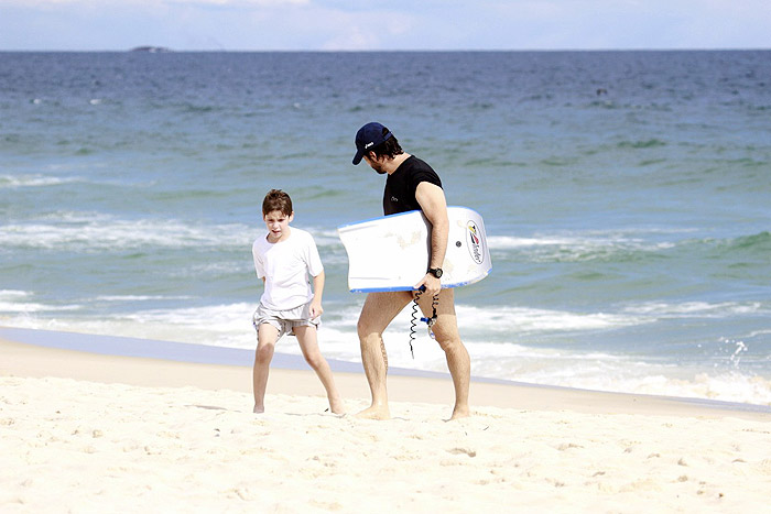 Murilo Benício brinca no mar com o filho