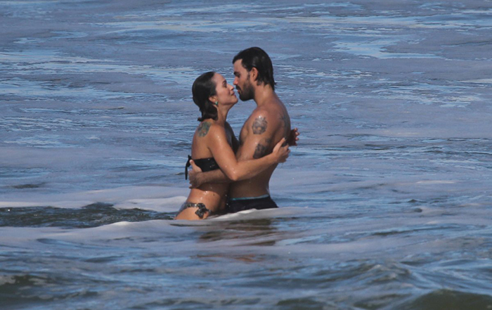 Juliano Cazarré troca beijos com a esposa na praia