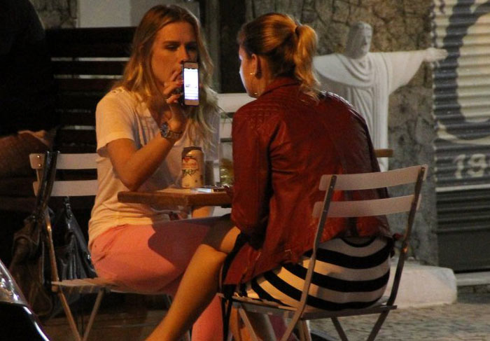 Fiorella mostra algo no celular para a amiga. O que será?