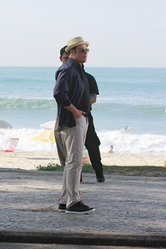 De chapeuzinho, John Travolta grava comercial de cachaça na orla da praia