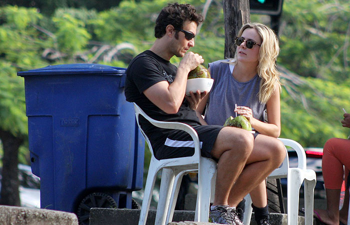 Gabriel Braga Nunes toma água de coco na Lagoa com a namorada