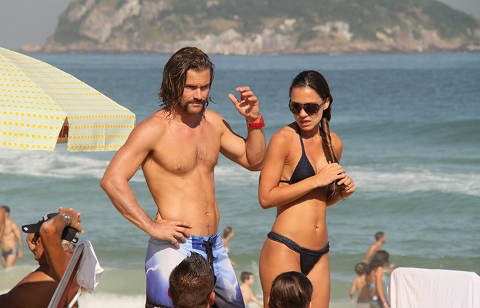 De cabelão e barba, Claudio Heinrich vai à praia com a namorada