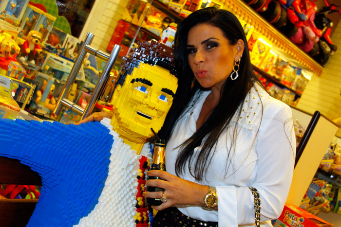 Solange Gomes bebe champanhe com boneco feito de Lego