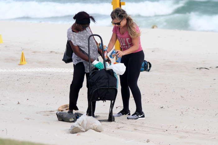 Fernanda Souza malha e ajuda catadora de latinhas, na praia