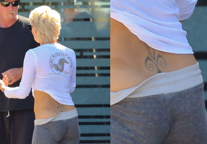 Ao lado do marido, Pamela Anderson é clicada com barriguinha de fora e tatuagem a mostra