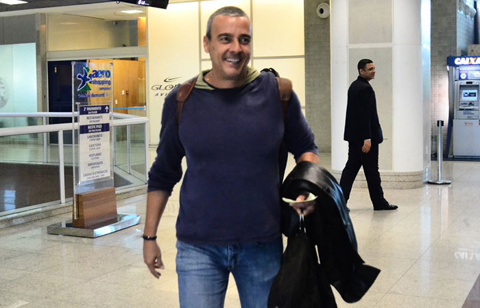 Alexandre Borges embarca sorridente no aeroporto Santos Dumont