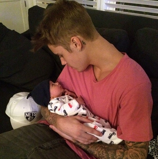 Justin Bieber posa com bebê no colo