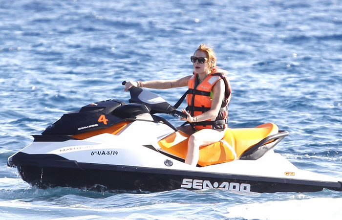 Lindsay Lohan quase mostra demais em dia de praia em Ibiza