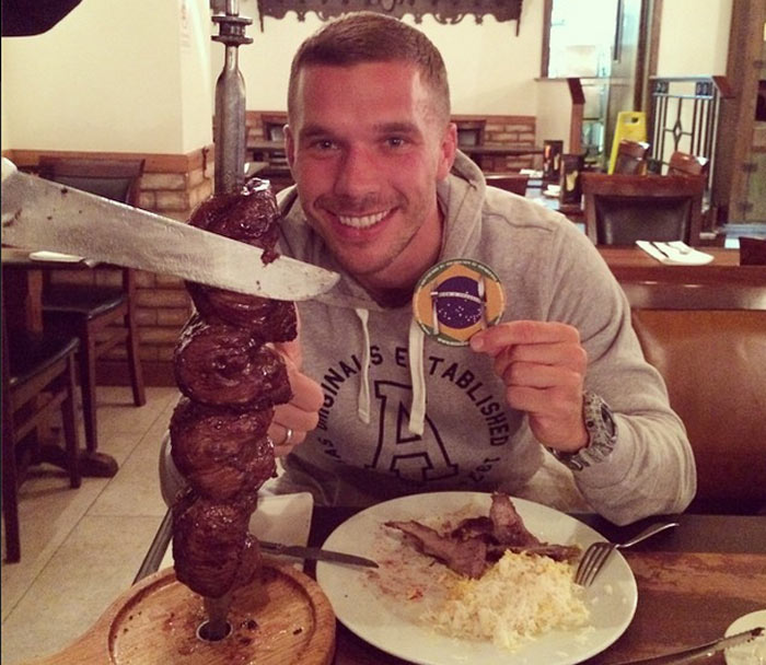Lukas Podolski devora churrasco para matar saudade do Brasil