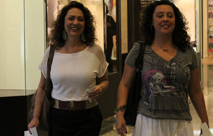 Sorridente, Eliane Giardini faz compras em shopping no Rio
