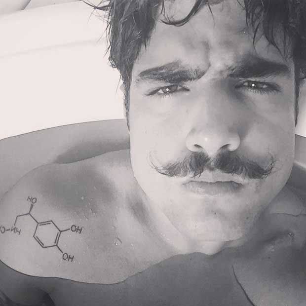 Na banheira, Caio Castro mostra tatuagem no ombro