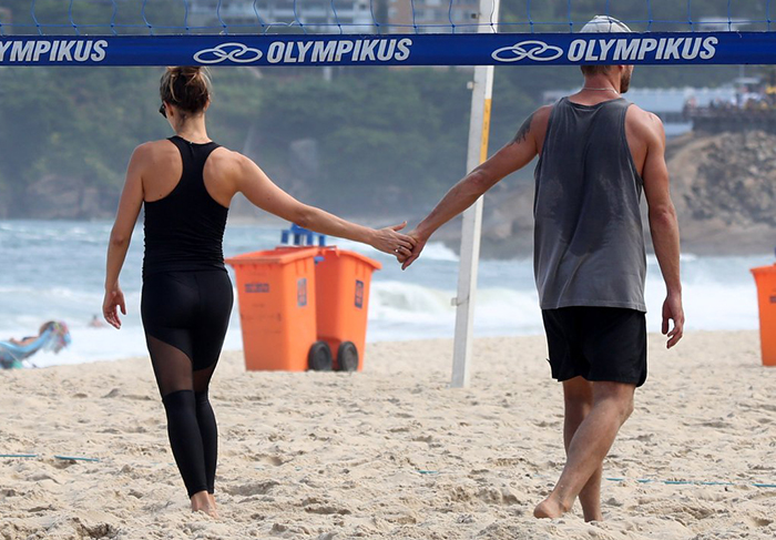 Entre um saque e outro, Fernanda Lima e Rodrigo Hilbert trocam beijos na praia