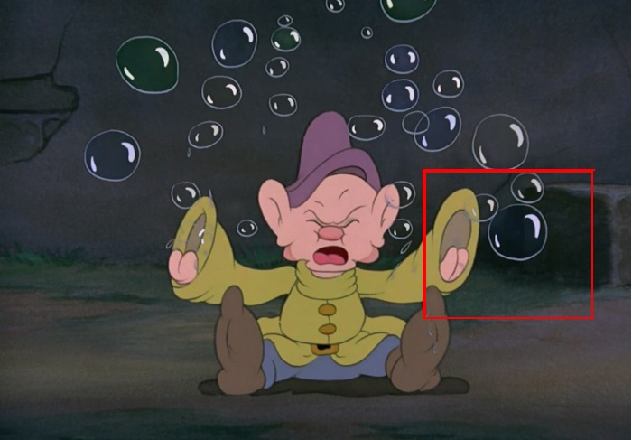 A imagem do símbolo da Disney aparece sendo formada pelas bolhas, ao lado da mão esquerda do personagem!