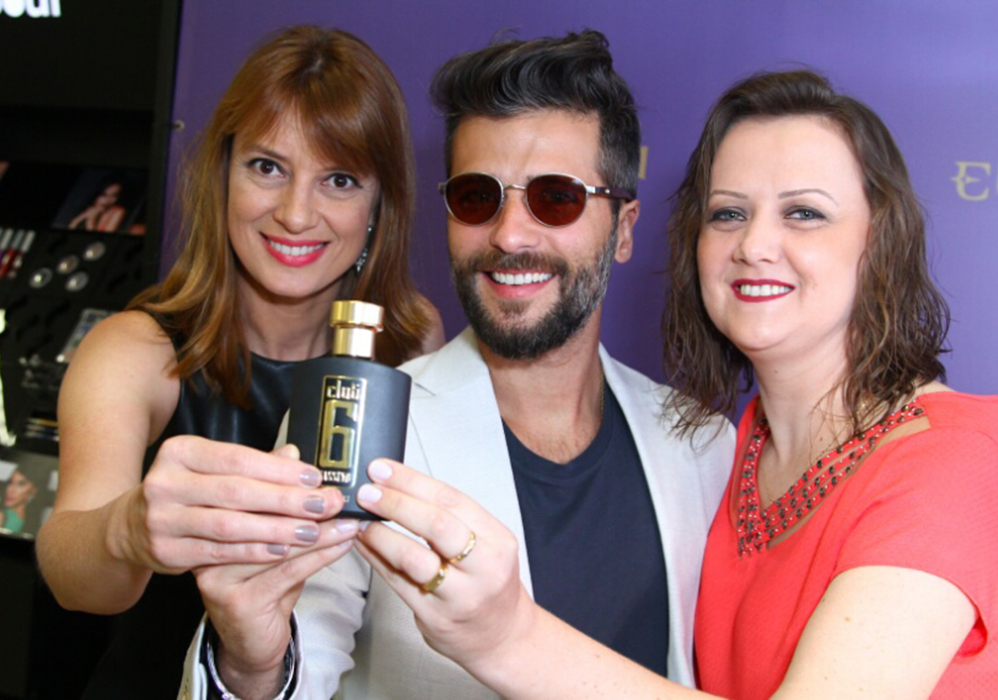 Bruno Gagliasso posa com as contratantes do evento mostrando o perfume