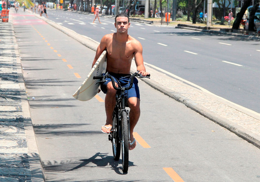 Para chegar à Ipanema e surfar, Sergio já se aqueceu ao pedalar na bicicleta