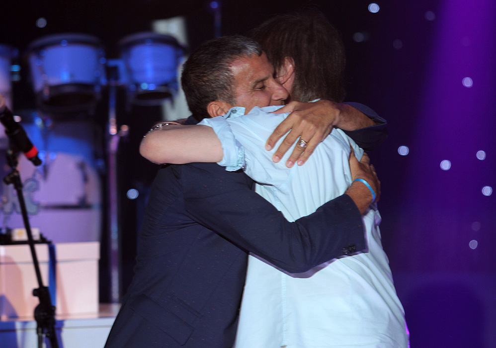 Roberto Carlos abraça Eri Johnson no palco do karaokê do Projeto Emoções Praia do Forte