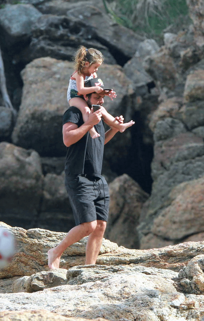 Bruno Gissoni carrega a filha nos ombros em passei por praia carioca