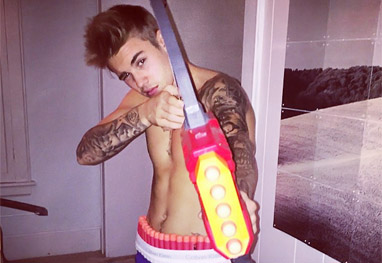 Sem camisa, Justin Bieber brinca com arma ao estilo bad boy: 'Engatilhada e carregada' - Reprodução