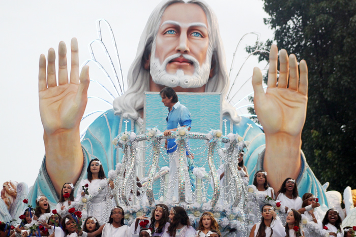 Roberto Carlos com crianças aos seus pés segurando rosas vermelhas