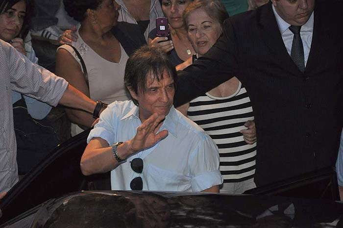 Roberto Carlos deixando o cemitério do Araça, em São Paulo, após enterro do corpo de sua filha Ana Paula. Mesmo abalado, o Rei acenou para a multidão que se concentrava no lugar