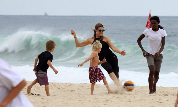 Fernanda Lima joga futebol com os gêmeos em praia carioca