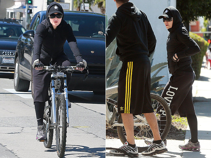 Madonna vai de bicicleta à academia com o corpo todo coberto
