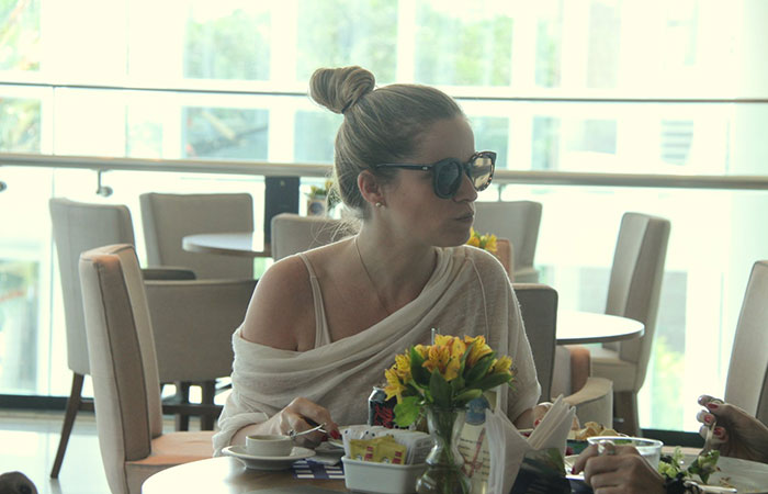 De óculos escuros, Bruna Di Tullio almoça com amiga em shopping carioca