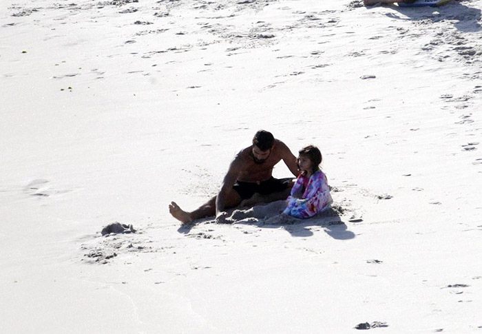 Cauã Reymond e Grazi Massafera aproveitam o dia na praia, juntos, com a filha