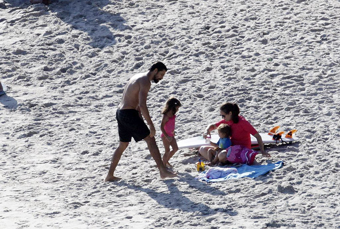Cauã Reymond e Grazi Massafera aproveitam o dia na praia, juntos, com a filha