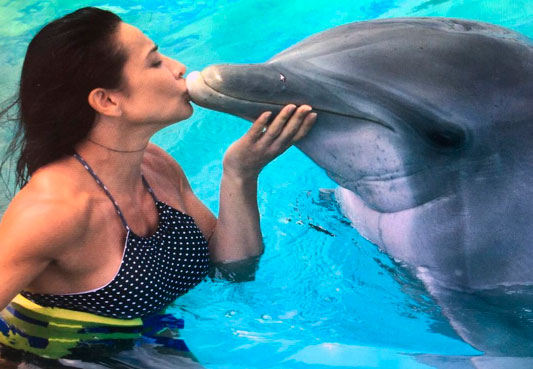 Scheila Carvalho lasca beijo em golfinho durante viagem