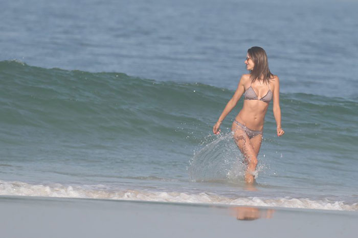 Alessandra Ambrósio mostra elasticidade na praia