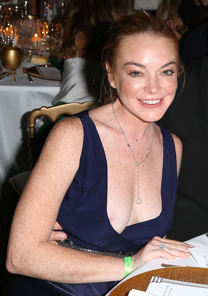 Lindsay Lohan deixa seio à mostra em festa
