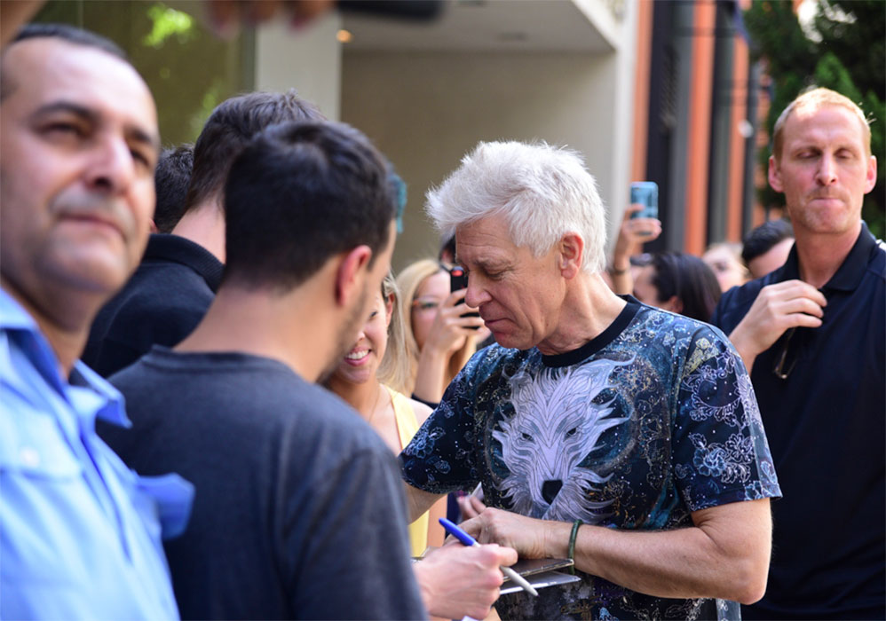 Baixista do U2 atende fãs na porta de hotel em São Paulo