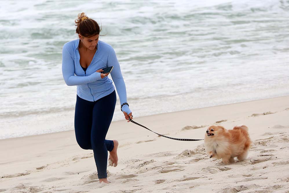 Giulia Costa brinca com cachorrinho na praia