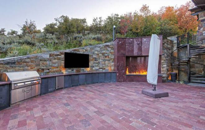 Parte da área externa, com TV, churrasqueira...