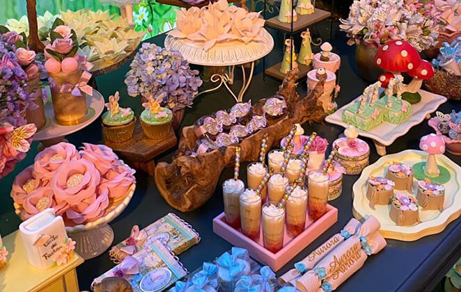 Mesa decorada e com diversas comidinhas na festa de 1 ano de Aurora, filha de Ferrugem